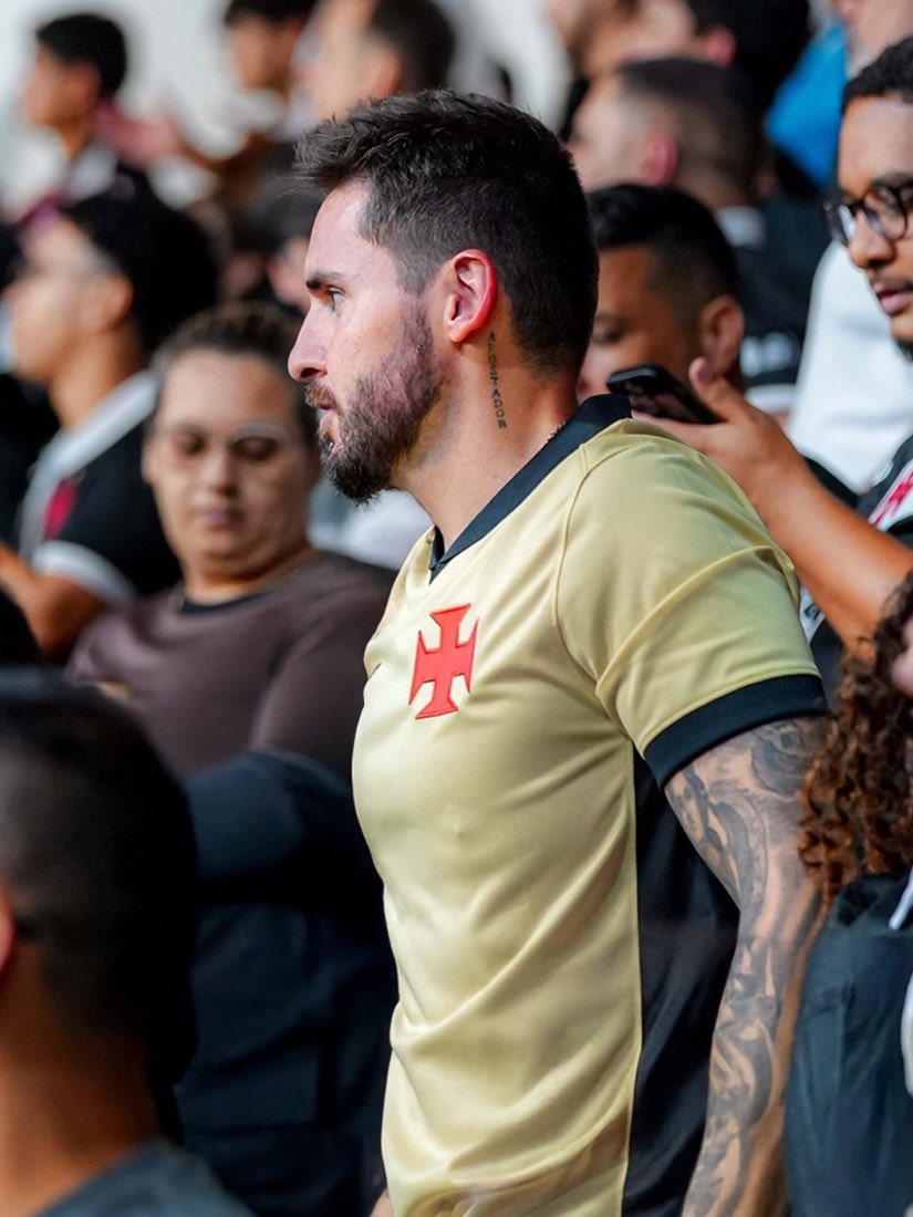 Mateus Caumo de perfil na arquibancada, de camisa amarela do Vasco